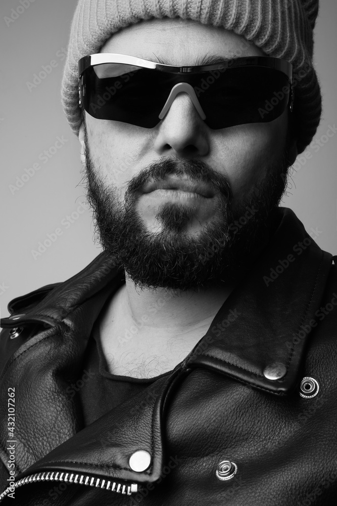 Fototapeta premium Vertical black and white portrait of handsome bearded man, wearing pink hat.