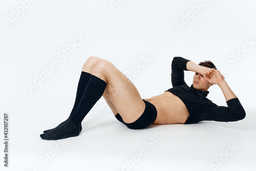 a fashionable man in a sweater underpants and socks lies on the floor