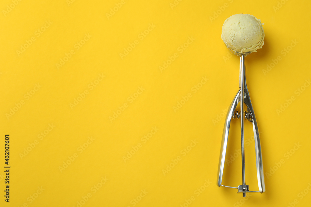 Scoop with ice cream on yellow background