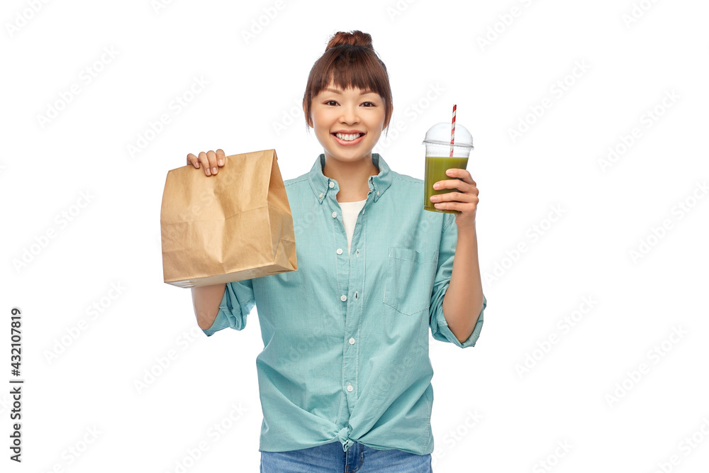eating and takeaway concept - asian woman drinking green vegetable juice or smoothie from plastic cup with straw and food in paper bag over white background eating and takeaway concept - asian woman drinking green vegetable juice or smoothie from plastic cup with straw and food in paper bag over white background