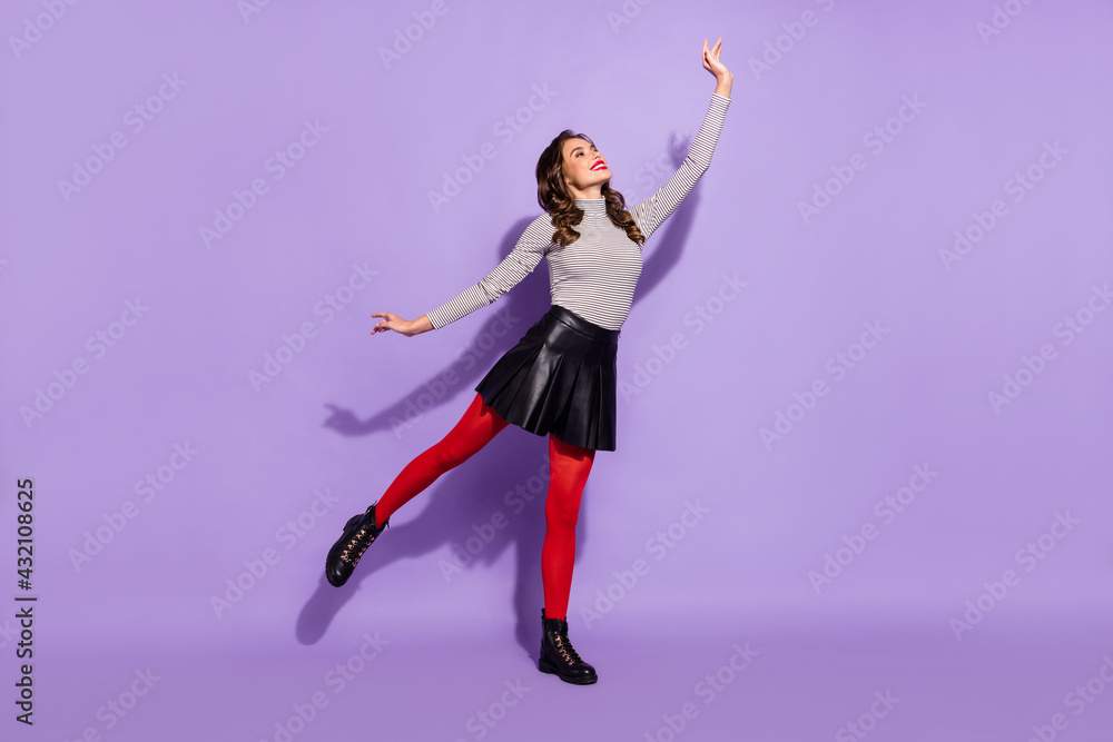 Full body photo of young charming girl happy positive smile look empty space isolated over purple color background Full body photo of young charming girl happy positive smile look empty space isolated over purple color background