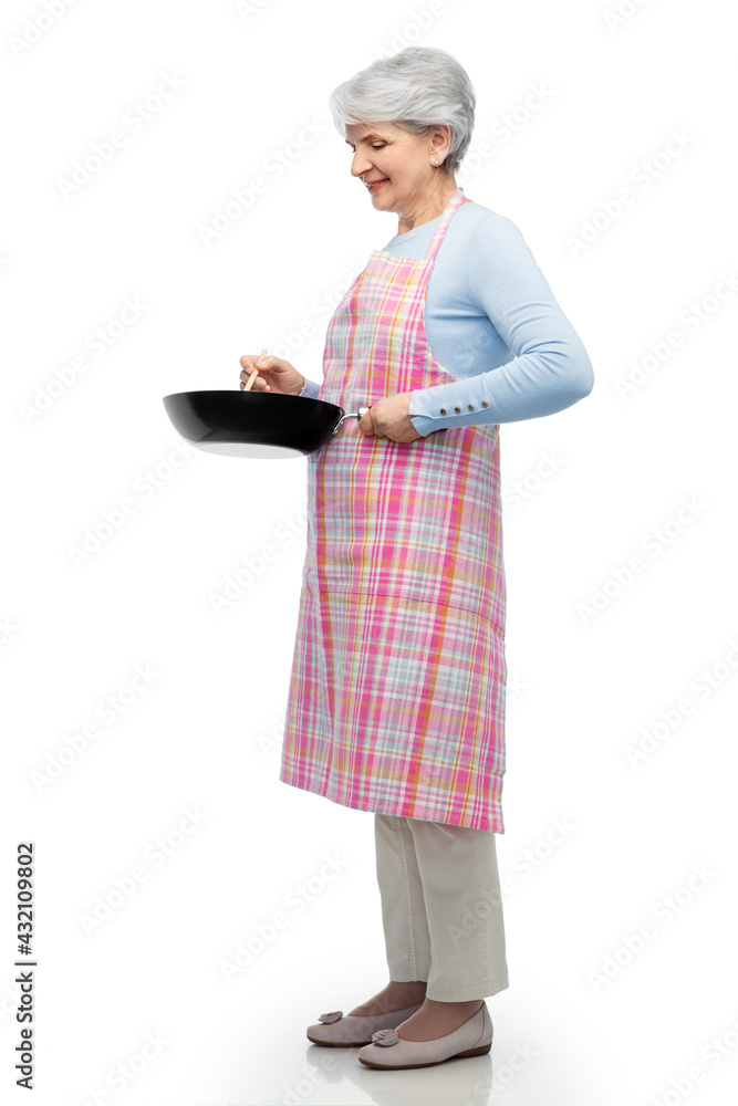 food cooking, culinary and old people concept - portrait of smiling senior woman in kitchen apron with frying pan over white background food cooking, culinary and old people concept - portrait of smiling senior woman in kitchen apron with frying pan over white background