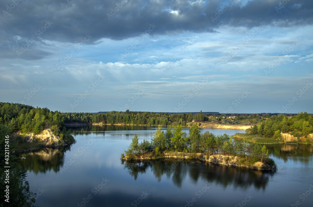 An old granite quarry and a formed lake with a sandy-rocky shore and tree-covered islands.