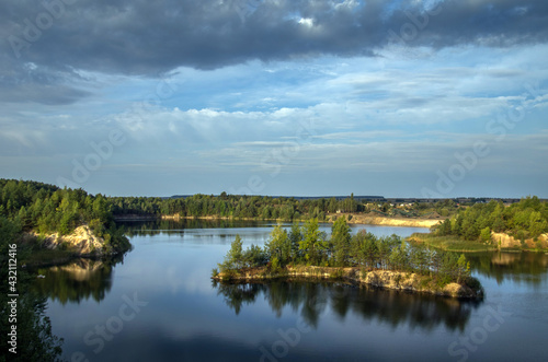 An old granite quarry and a formed lake with a sandy-rocky shore and tree-covered islands.