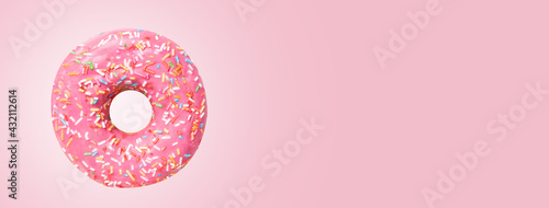 Funny whole pink doughnut on pink background. Banner format with copy space. Celebration poster. 