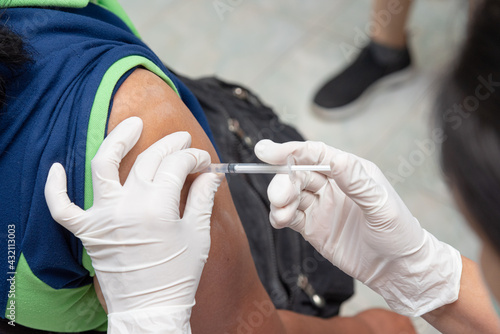 Close up doctor  nurse holding syringe making covid-19 vaccination injection dose in shoulder patient. Corona virus treatment side effect  close up view. Flu Vaccination Injection on Arm.
