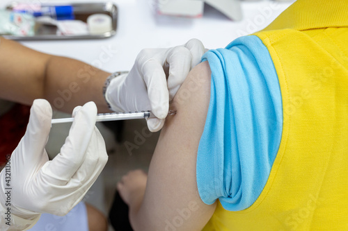 Close up doctor, nurse holding syringe making covid-19 vaccination injection dose in shoulder patient. Corona virus treatment side effect, close up view. Flu Vaccination Injection on Arm.