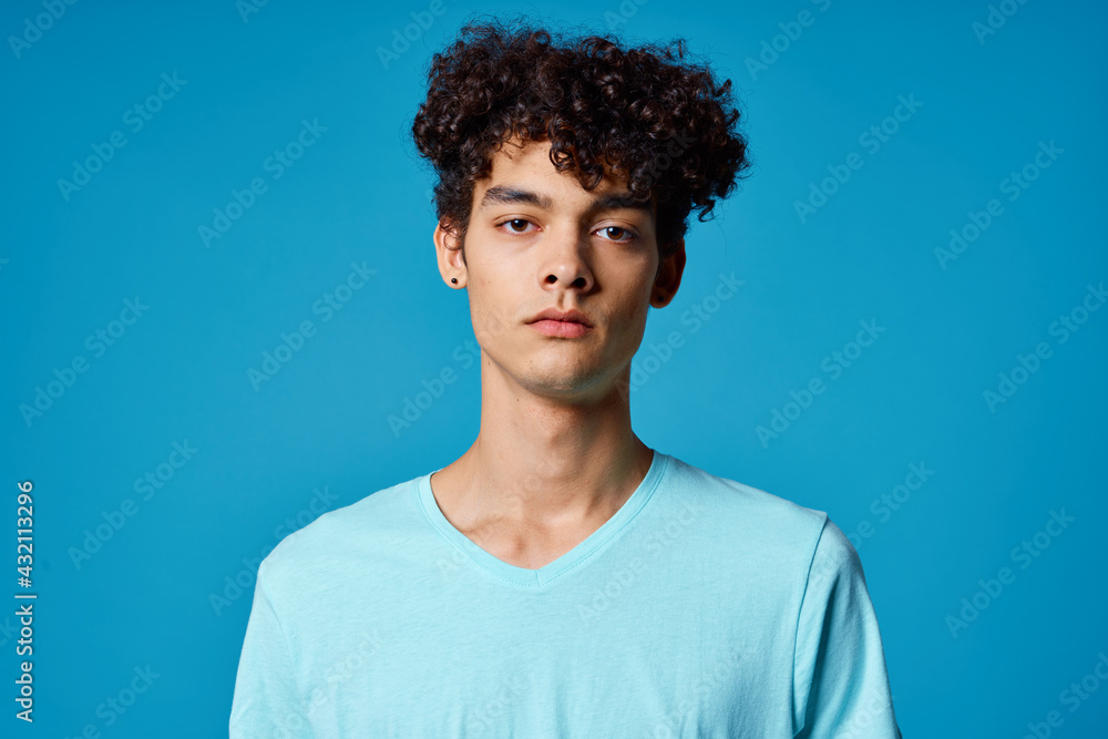 guy with curly hair in blue t-shirt cropped view studio guy with curly hair in blue t-shirt cropped view studio