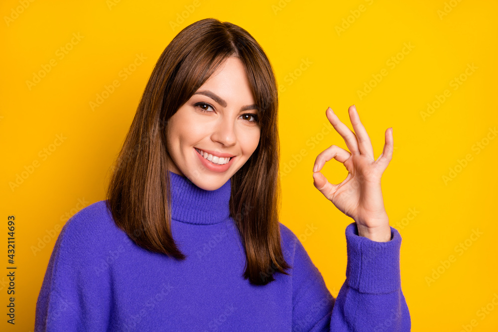 Portrait of attractive content cheerful girl showing ok-sign ad excellent solution isolated over bright yellow color background Portrait of attractive content cheerful girl showing ok-sign ad excellent solution isolated over bright yellow color background