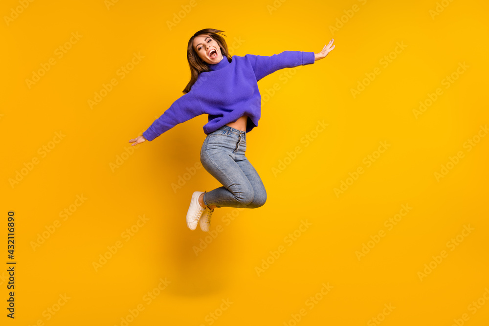 Full length body size view of attractive cheerful carefree girl jumping having fun fooling isolated over bright yellow color background