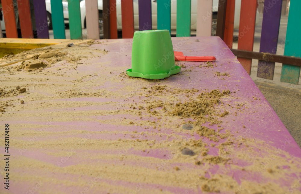 Children's toys for playing with sand lie in the sandbox on the playground in sunny weather