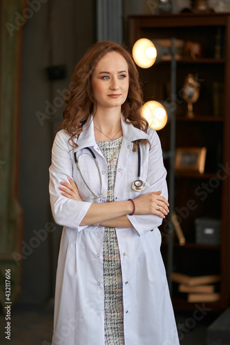 The girl in a white robe. Beautiful girl doctor in the office.