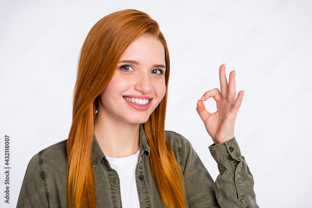 Photo of young beautiful charming smiling lovely woman showing okay sign recommend isolated on grey color background Photo of young beautiful charming smiling lovely woman showing okay sign recommend isolated on grey color background