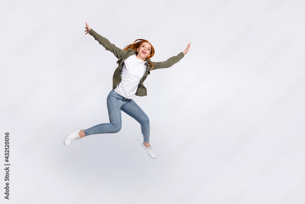 Full length body size view of attractive carefree cheerful girl jumping flying isolated over gray pastel color background Full length body size view of attractive carefree cheerful girl jumping flying isolated over gray pastel color background