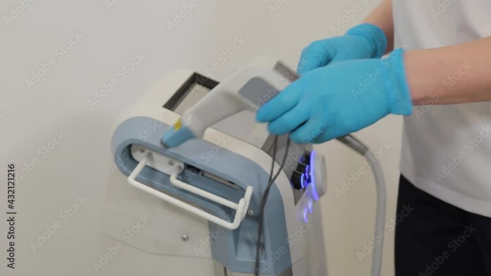 Woman beautician turns on the laser in the beautician office. Woman beautician turns on the laser in the beautician office.