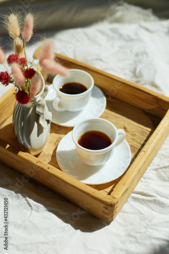 Breakfast in bed, try with two cups coffee and flower in sunlight at home