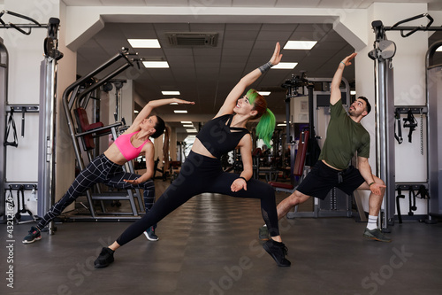 Group of people doing stretching exercises in a gym