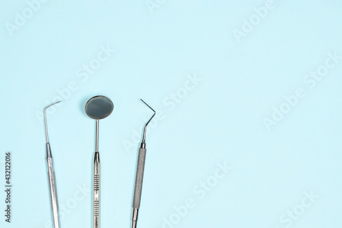 Medical dental instruments on light blue background with copy space. Flat lay close up top view on dental equipment. Tooth care, dental hygiene and health concept.
