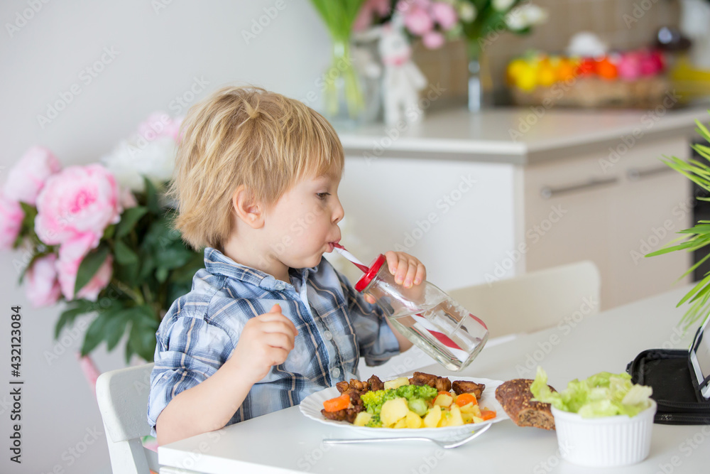 Little toddler child, blond boy, eating boiled vegetables, broccoli, potatoes and carrots with fried chicken meat at home