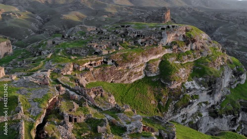 Eastern Turkey, Mesopotamia, the ancient city of Hasankeyf, caves in the rock. Aerial Drone Footage at sunset Time on the Coast of Tigres River photo