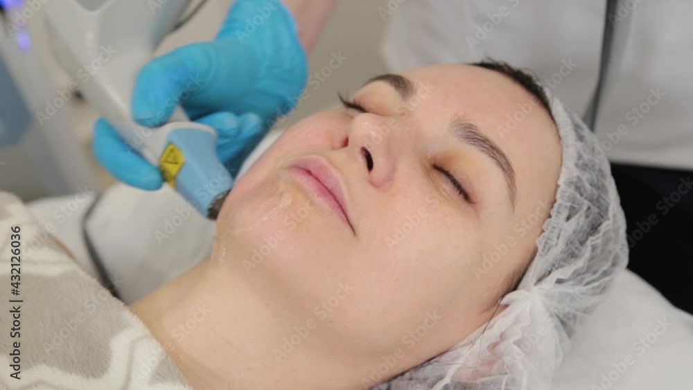 Woman beautician doing laser facial rejuvenation. Woman beautician doing laser facial rejuvenation.