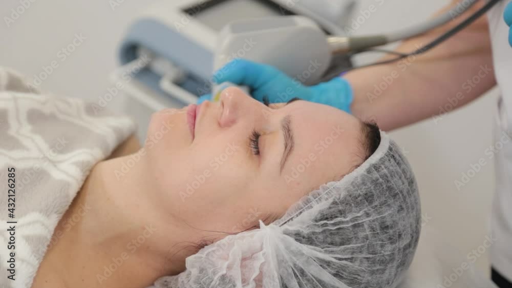 Woman beautician doing laser facial rejuvenation. Woman beautician doing laser facial rejuvenation.