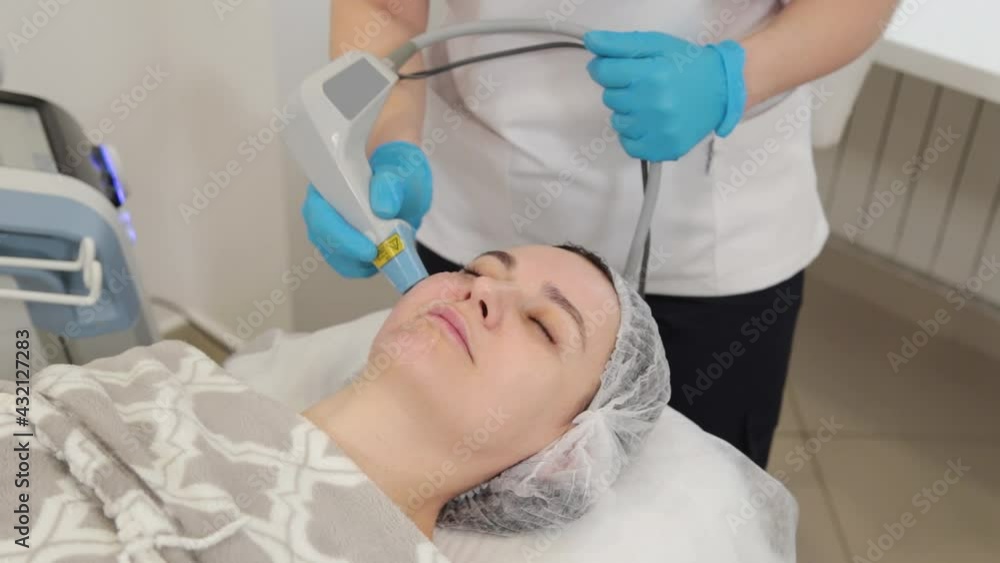 Woman beautician doing laser facial rejuvenation. Woman beautician doing laser facial rejuvenation.