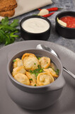 Russian dumplings in a pot in broth with herbs