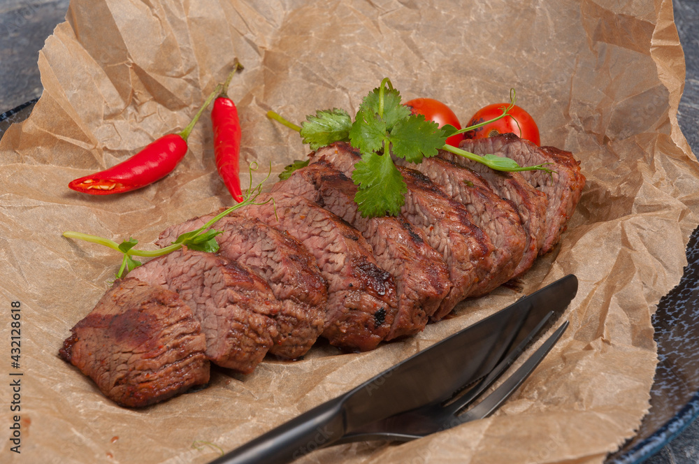 beef steak on parchment decorated with pepper and herbs