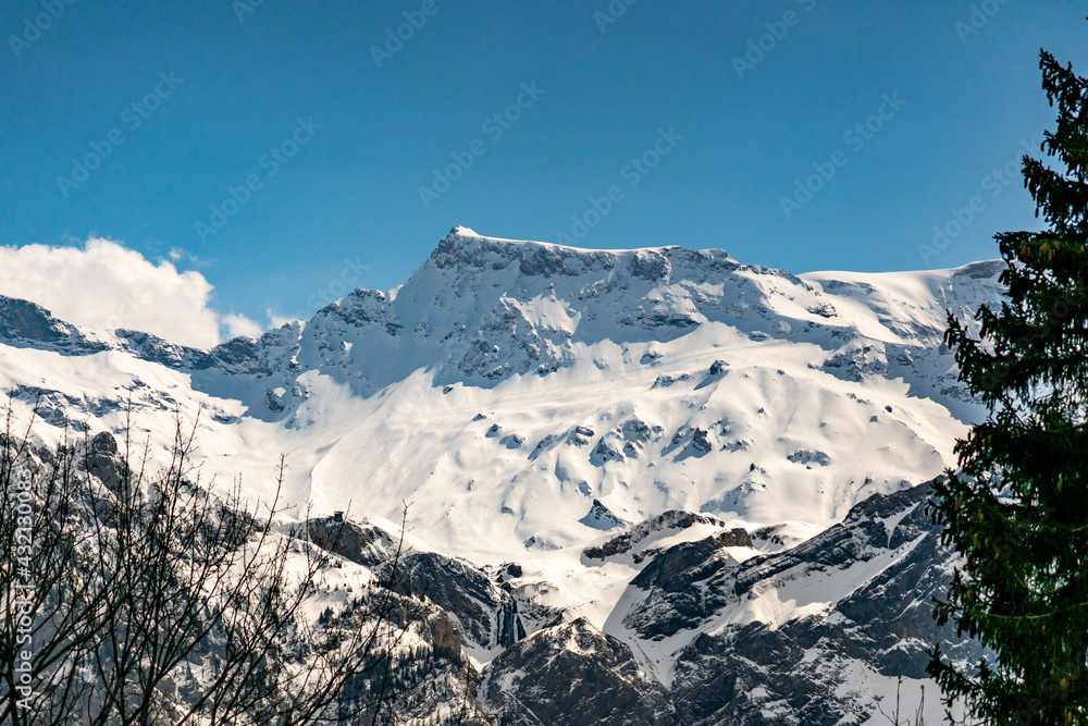 Obraz premium Wildstrubel und Engstligenalp mit frischen Spuren von Skiwanderern im Neuschnee. snow covered mountains in Swiss alps. ski hiker tracks in the fresh snow. avalanches on the steep slopes. Schneebretter