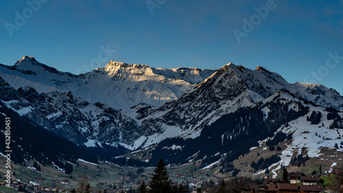 Wildstrubel und Steghorn überragen die Engstligenalp in Adelboden. Schnee von gestern liegt im Frühling auf den Wäldern, Wiesen und Dächern. snowy mountains in Switzerland photo
