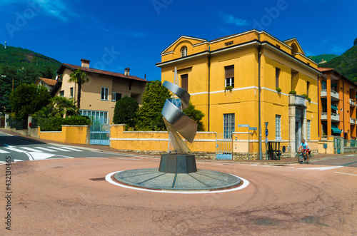 Sculpture by traffic circle against building in municipality