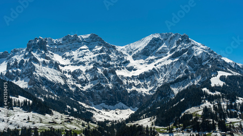 Grosser Lohner und Mittagshorn bei Adelboden in den Schweizer Alpen, frisch verschneite Berge im Frühling, Schnee von gestern, beleuchtete und schwarze Felsen und glänzende Schneefelder im Kontrast