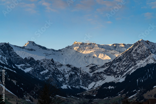 Wildstrubel und Steghorn überragen die Engstligenalp in Adelboden. Schnee von gestern liegt im Frühling auf den Wäldern, Wiesen und Dächern. snowy mountains in Switzerland