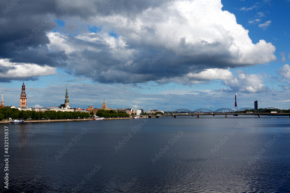 Panoramic view of the old town Riga, the Daugava river and the railway bridge. Beautiful cityscape with soft clouds on the blue sky