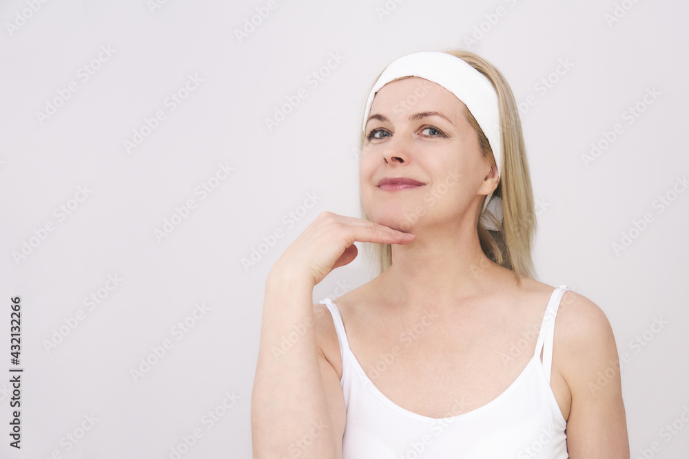 middle-aged woman makes self-massage of the face, exercise to get rid double chin middle-aged woman makes self-massage of the face, exercise to get rid double chin
