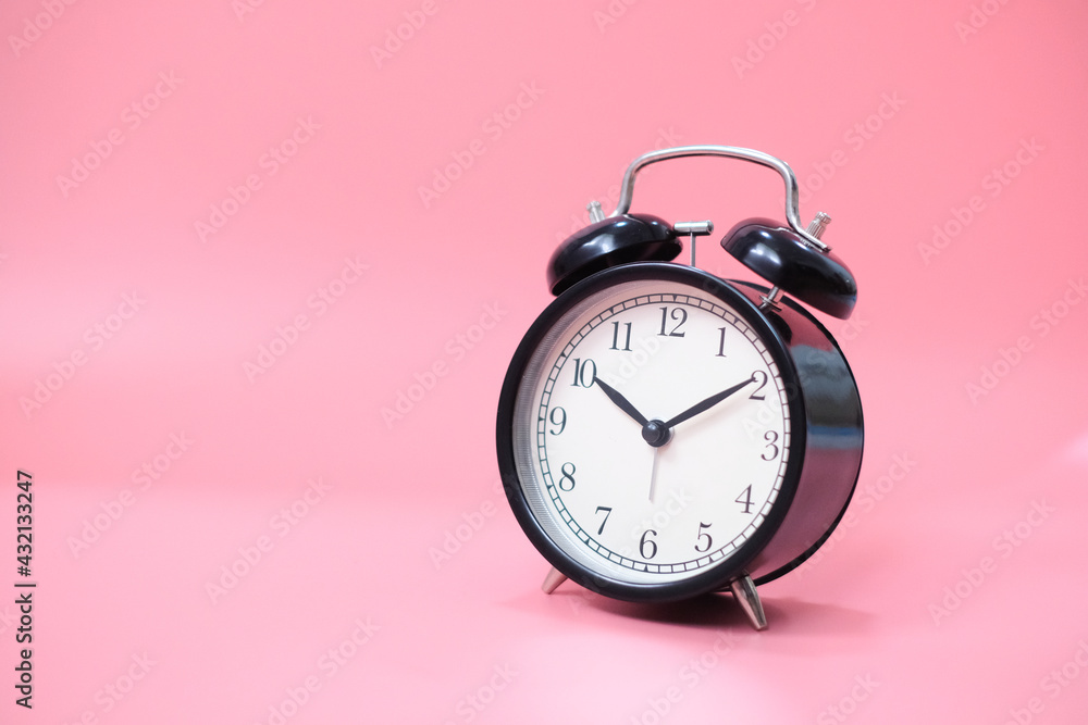 Black vinatge alarm clock with pink background. Black vinatge alarm clock with pink background.