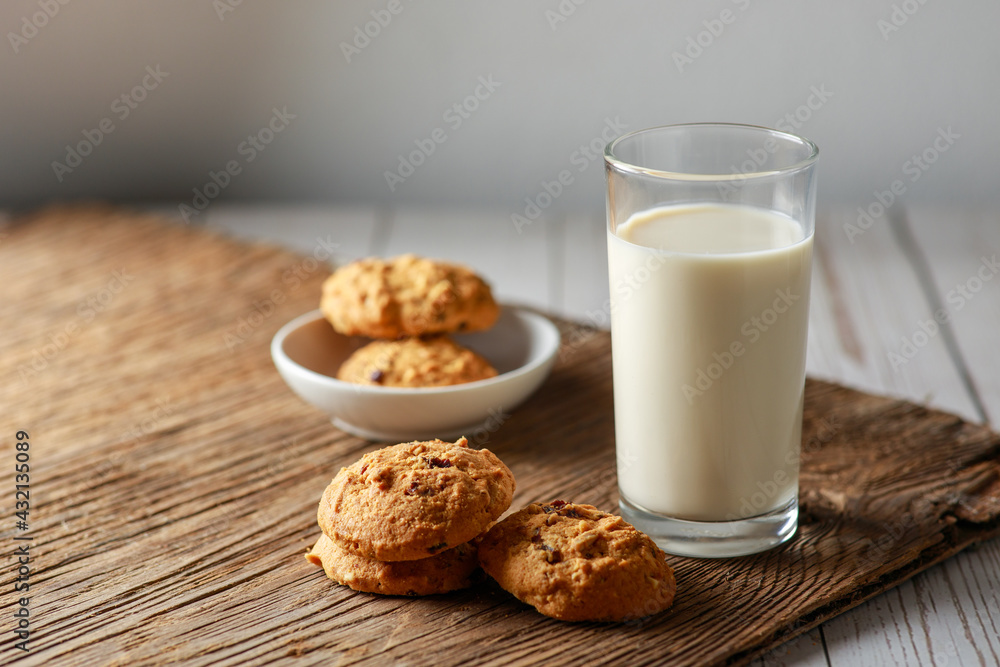 A fresh glass of milk with chocolate chip cookies on white wooden background. Healthy eating. Selective focus. A fresh glass of milk with chocolate chip cookies on white wooden background. Healthy eating. Selective focus.