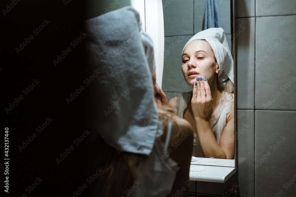 Use Wash Off Face Mask, Using Peel-Off Mask Correctly. Young woman in towel on her head wash face after removing mask in bathroom. Use Wash Off Face Mask, Using Peel-Off Mask Correctly. Young woman in towel on her head wash face after removing mask in bathroom.