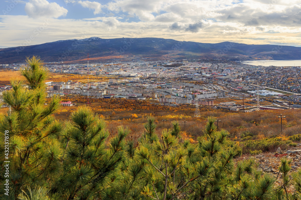 View of the city of Magadan. Autumn landscape with a seaside town and hills. Top view of the streets and buildings. Magadan, Magadan region, Siberia, Far East of Russia.