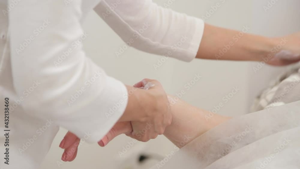 Woman beautician doing hand massage to client. Woman beautician doing hand massage to client.