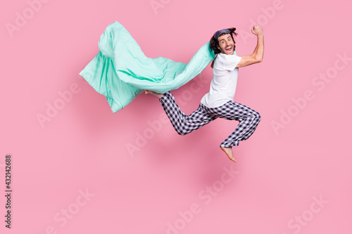 Full size photo of happy funky funny smiling man jumping with blanket good morning isolated on pink color background