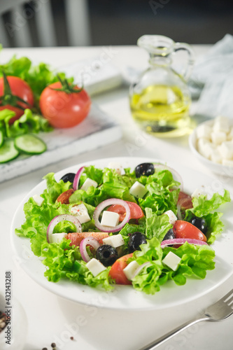 Greek salad of fresh cucumber, tomato, lettuce, red onion, feta cheese and olives with olive oil