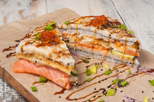Onigirazu sushi with salmon, deep-fried white fish, cucumber, red caviar and tuna chips