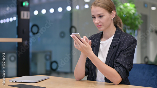 Serious Young Businesswoman using Smartphone 