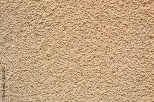 Textured background, yellow wall with stone in close-up