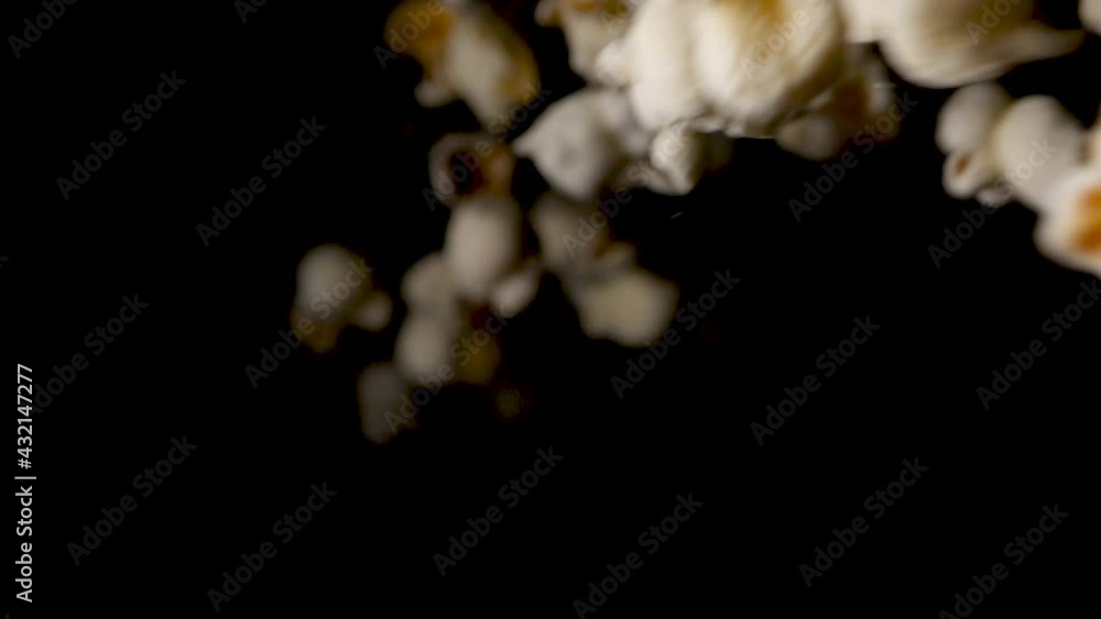 Sweet popcorn drops on isolated black background in slowmotion. Sweet popcorn drops on isolated black background in slowmotion.