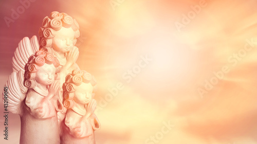 Three angels praying, religious background with space for text. Golden tones.