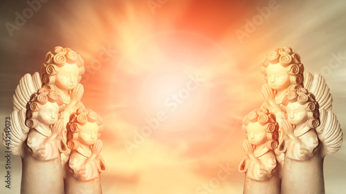 Angels in the sky praying to the holy light of God, religious background with space for text on center. Golden divine light.