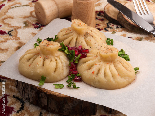 khinkali with beef, garnished with pomegranate seeds and herbs. close up